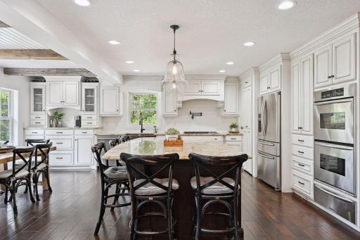 Stunning and massive, the white kitchen features custom cabinetry with drawers, pull-outs, built-ins, and a hidden pantry.