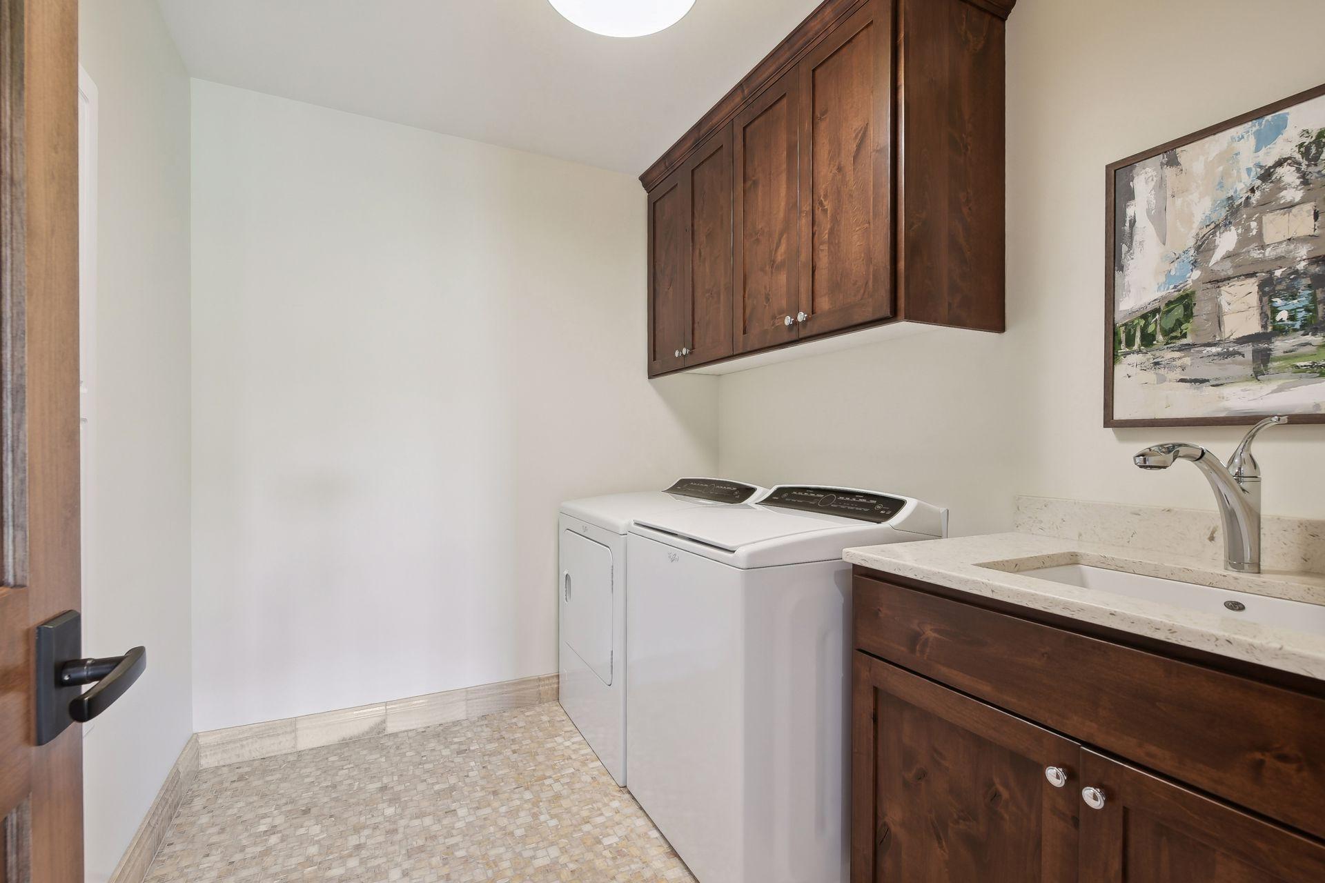Upper level 2nd laundry room with sink, cabinets and built-in ironing table