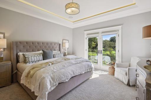 Main floor primary bedroom with French door balcony doors overlooking golf course