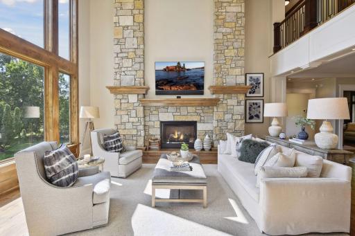 Two story great room, 18ft coffered ceiling, gas fireplace, accent lighting, Sony TV with soundbar is connected to surround sound and kitchen speakers. Hidden in-wall speakers