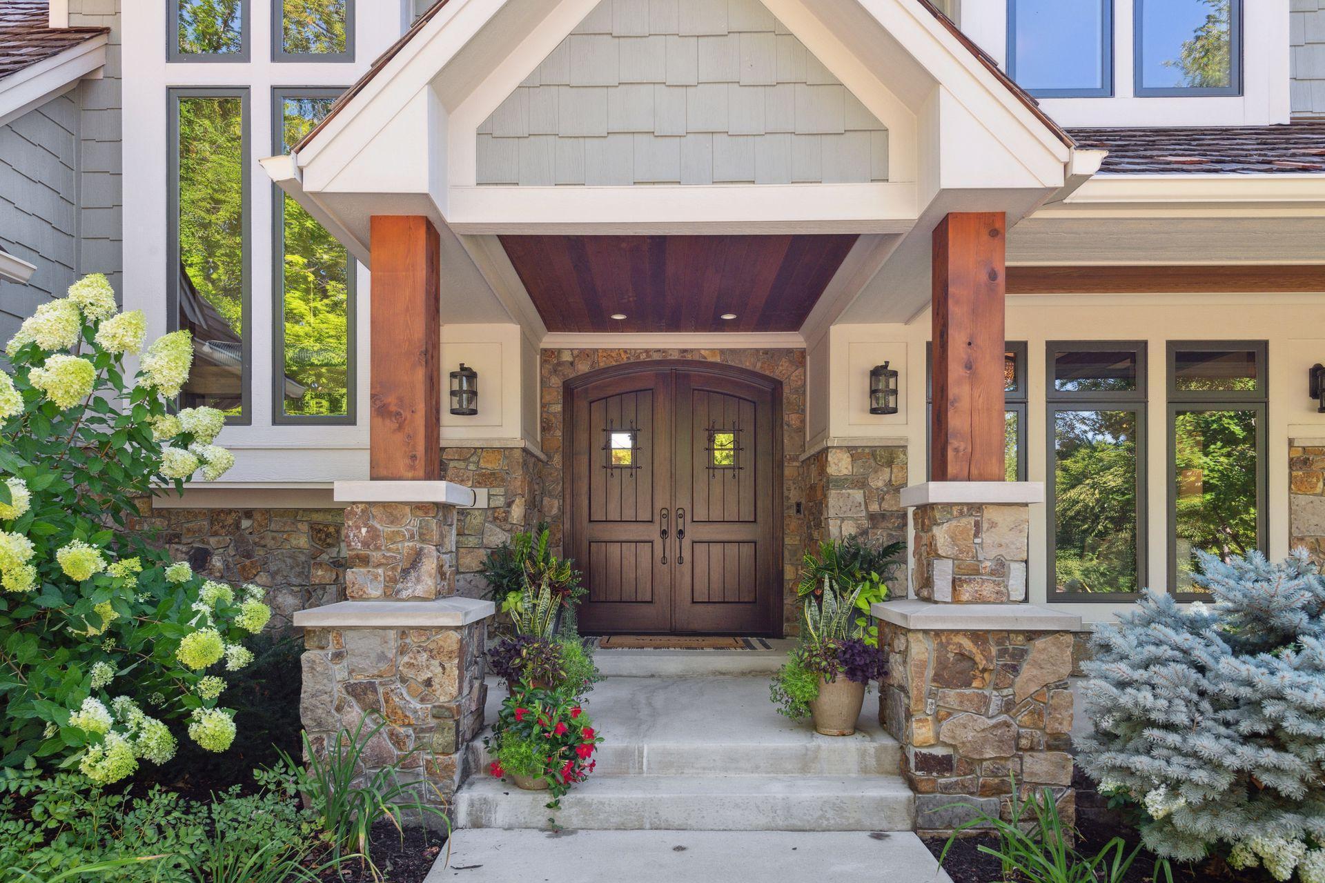 aesthetically pleasing front entrance with porch and double wood doors.