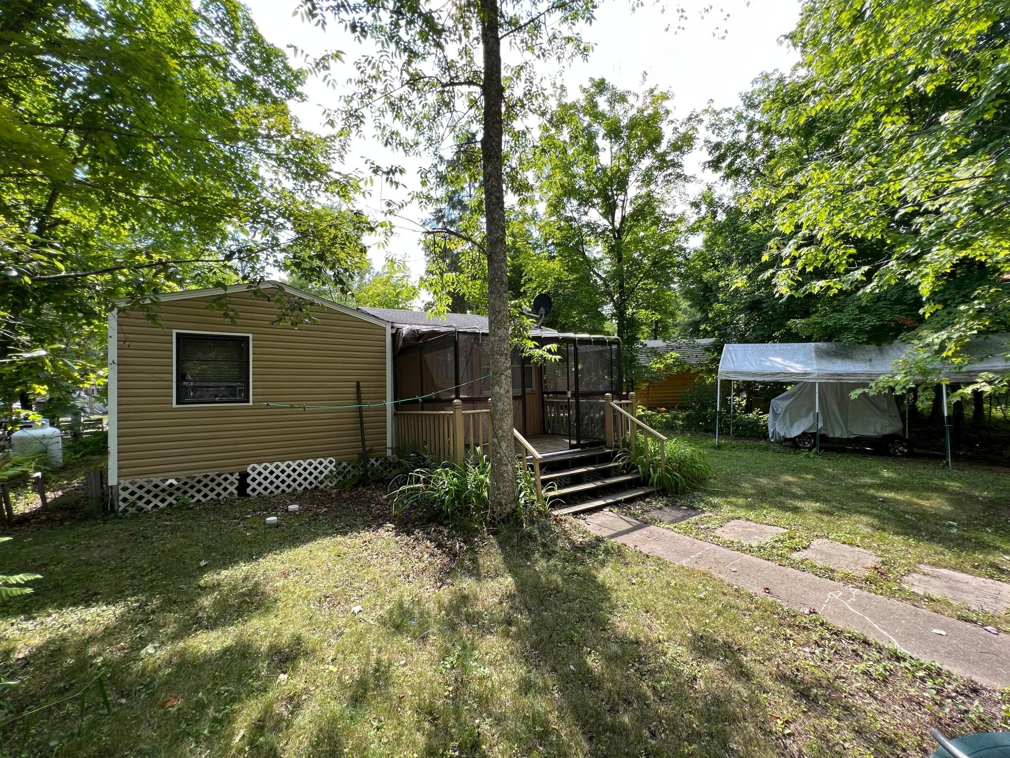 One more view of the exterior with the carport beyond to the right.