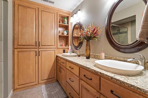 Three quarter lower bath with dual sinks and a large storage area for linens and towels.