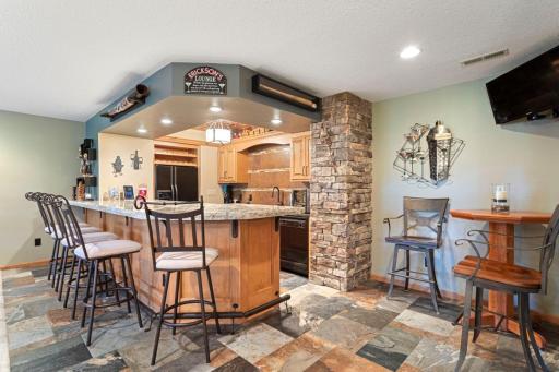 Custom bar with huge granite top, coffered ceiling Pub table seating to the side.