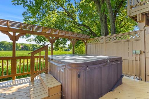 Room for seating alongside the hot tub. Side stairs lead to out lot and fire pit area.