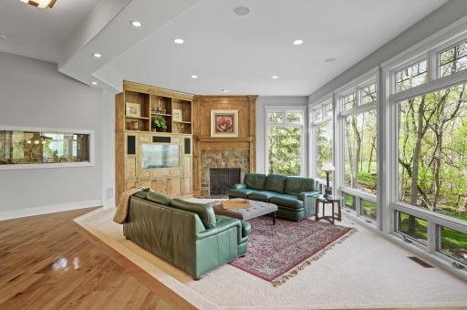 The gorgeous living room presents a full wall of floor to ceiling windows for unobstructed backyard views, custom built-in entertainment center, and gas fireplace. Built-in surround sound found throughout the home and outside too!