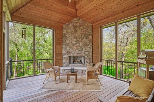 Off of the kitchen and dining area you can access both the deck and the magnificent screened-in porch with cedar surround, vaulted ceiling, wood-burning fireplace and incredible private backyard views.
