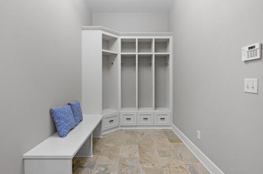 Mudroom with built-in storage and access to the attached heated 3-car garage with tons of storage, workbench, and even a dog washing area!