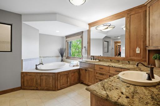 Beautiful private bathroom has a soaking tub perfect for relaxing after a long day, dual vanities, granite countertops, and more.