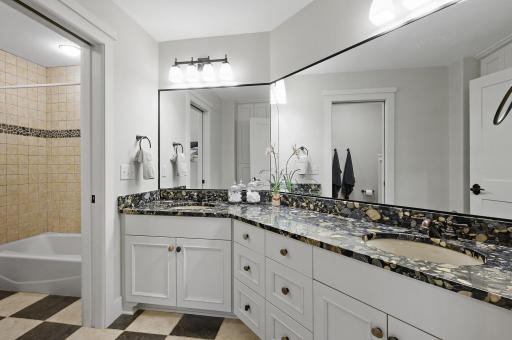Full upper level shared bathroom with expansive vanity and dual sinks.