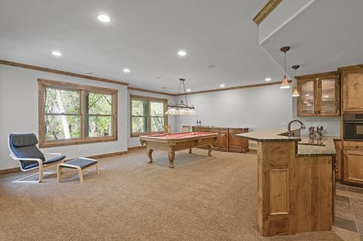 Recreation area with a pool table (stays with the home)! Tons of light pouring into the lower level through large windows providing a wonderful private treed backyard view.