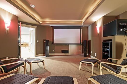 A home theater featuring a 92-inch projector screen and 9.1 surround sound system. You will absolutely fall in love this space - what a great spot to hang out and enjoy movies together!