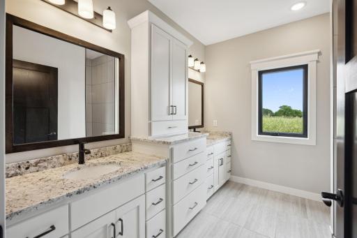 Owner's suite private bathroom with dual vanity and walk-in tile shower. Wonderful natural light from the west.