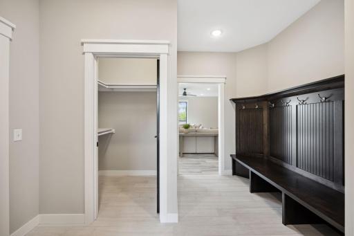 Mudroom with custom built bench/locker system. Coat/overflow storage. Half bath and laundry in this space.