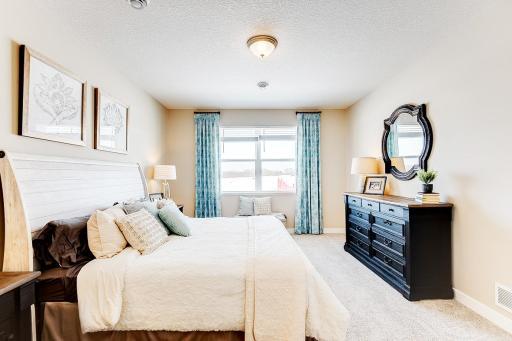 Primary bedroom with private en suite and walk-in closets has space for all of your bedroom furniture needs. Staged model photos. See listing agent for home specific selections.