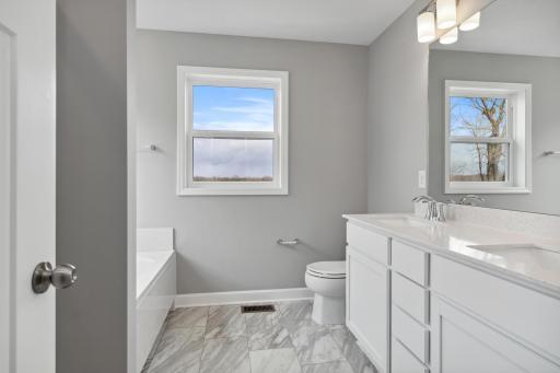 Private Owner's Bathroom separate soaking tub and oversized low maintenance shower.