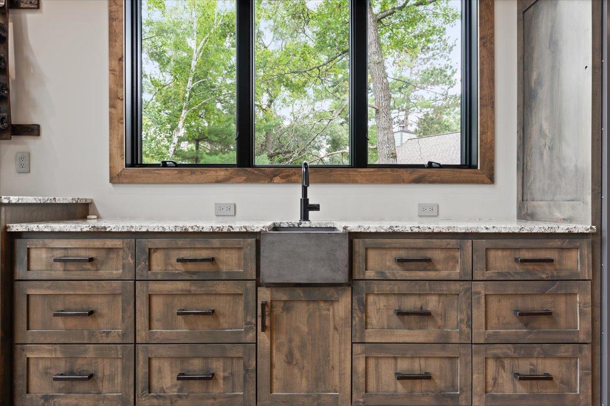 Wet bar near the main living room features a Viking beverage fridge, ice maker, sink and several cabinets/drawers for storage.