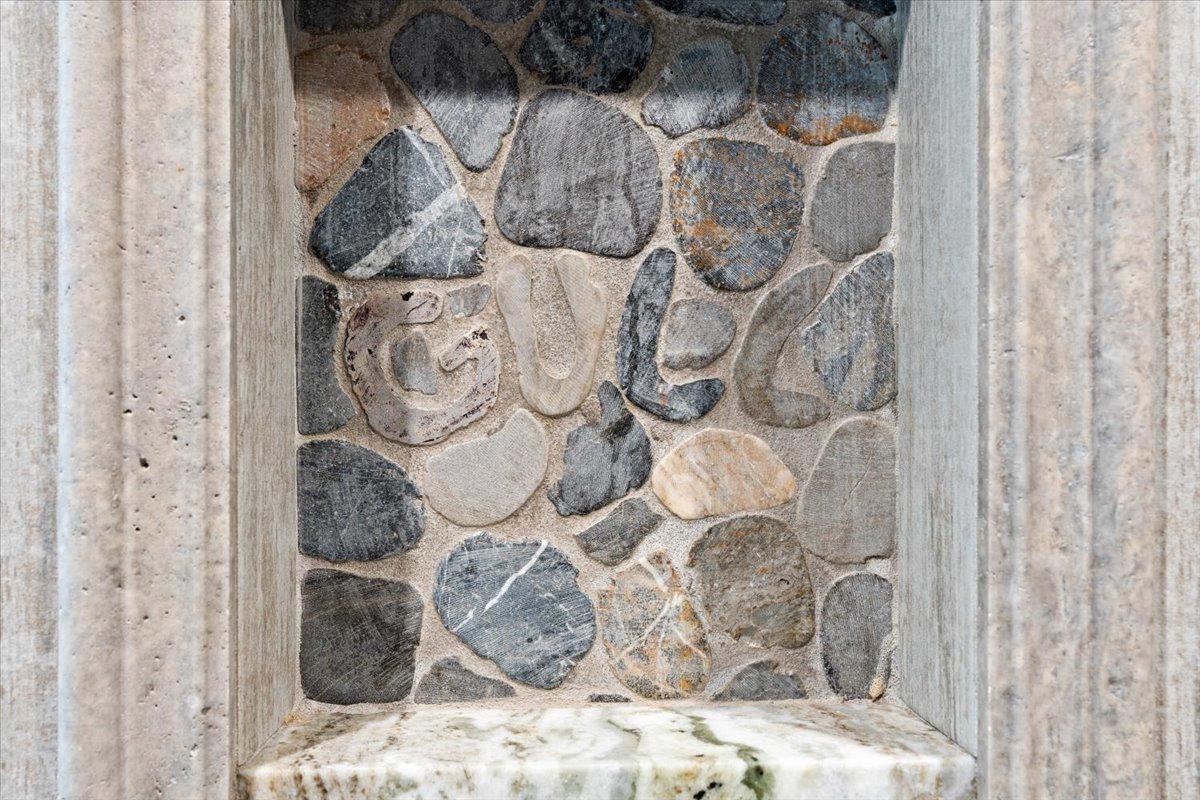 Custom inlayed stonework in each of the tile showers.