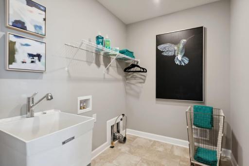 Lewis upper level laundry room with utility sink. *Please note, photos are of a similar model home, features and colors in actual home will vary. Please contact listing agent for exact specifications.