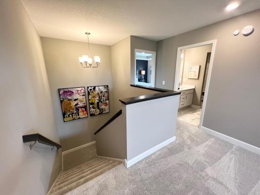Stairway and landing area/loft upper level. *Please note, photos are of a similar model home, features and colors in actual home will vary. Please contact listing agent for exact specifications.