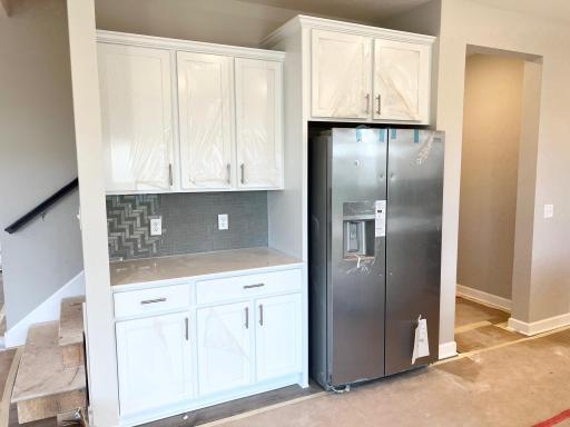 Kitchen area with stainless steel refrigerator.