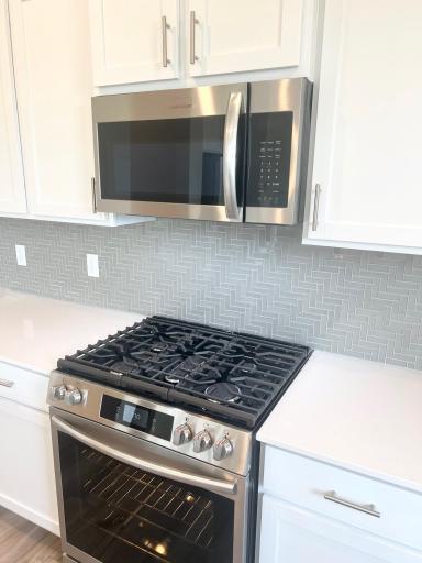 Five burner gas range with air fryer and microwave. Beautiful backsplash!