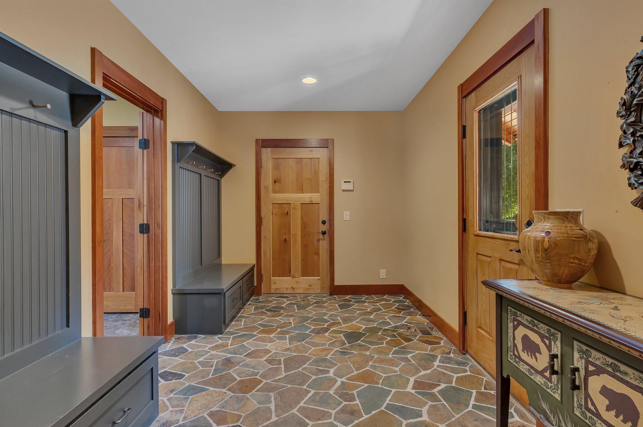 This spacious mud room is sure to impress. As you enter, you'll immediately notice the two exquisite solid wood built-in benches and underfoot, you will find stunning tile flooring that is both gorgeous and practical.