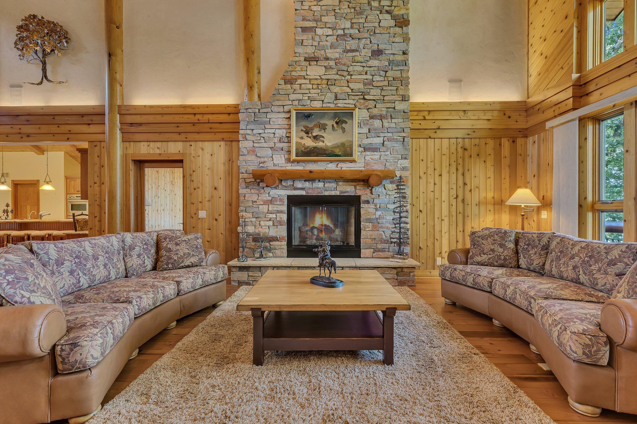 A stone double-sided fireplace stands as a centerpiece, offering both physical and visual warmth. It's the perfect spot to gather with loved ones, sharing stories and laughter while the fire creates a soothing ambiance.