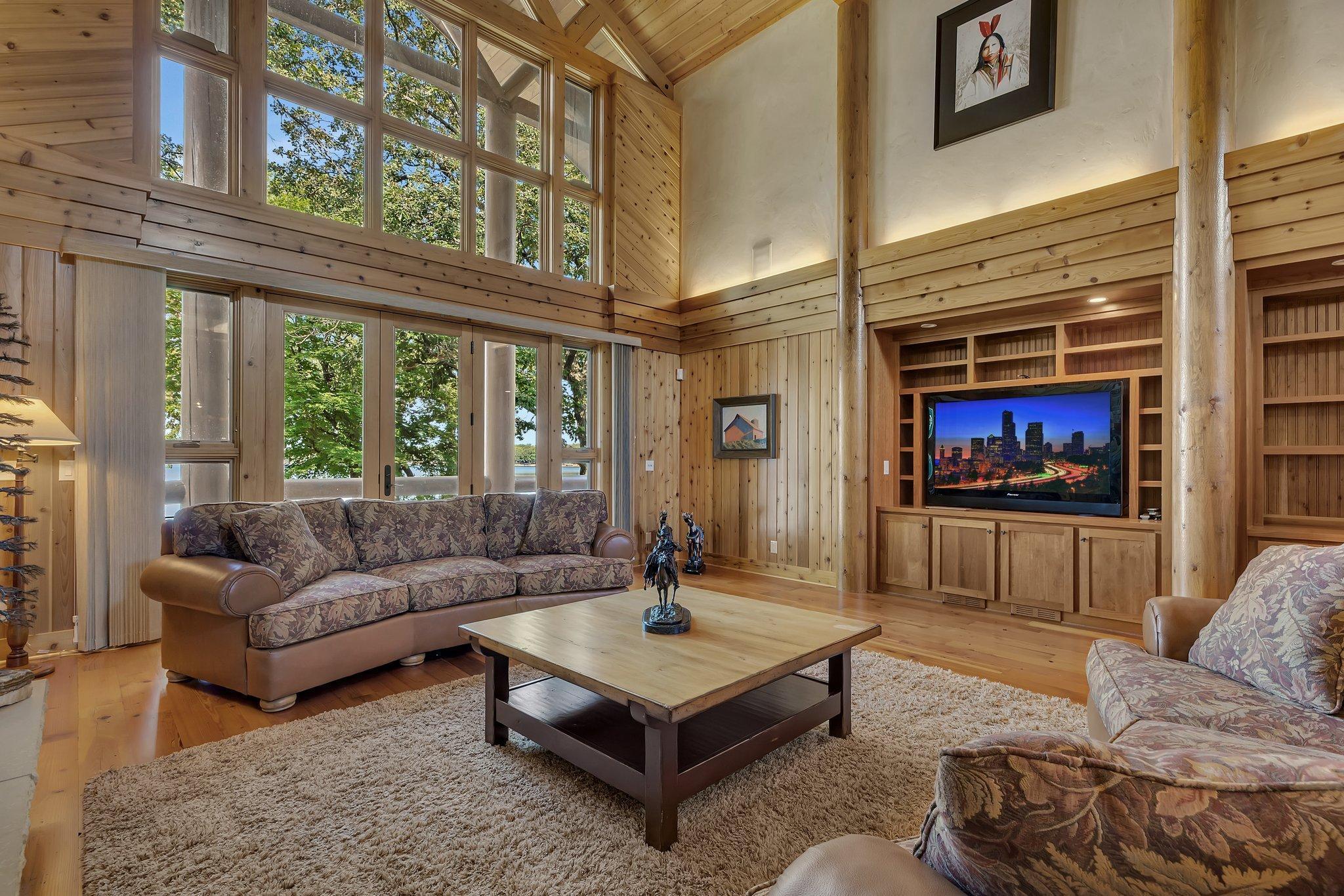 This meticulously designed living space has exquisite custom cabinets that elevate both style and convenience. Your eyes are immediately drawn to the stunning custom built-in for the television and beautifully crafted desk area.