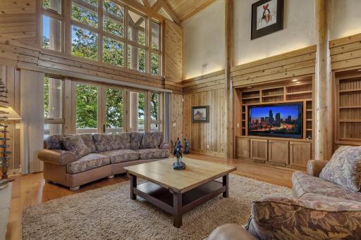This meticulously designed living space has exquisite custom cabinets that elevate both style and convenience. Your eyes are immediately drawn to the stunning custom built-in for the television and beautifully crafted desk area.