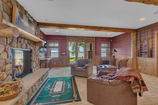 The walk-out basement features a spacious family room, designed for relaxation and togetherness. This room offers a harmonious blend of elegant dÃ©cor, stone fireplace and an abundance of natural light streaming in from the lakeside windows.