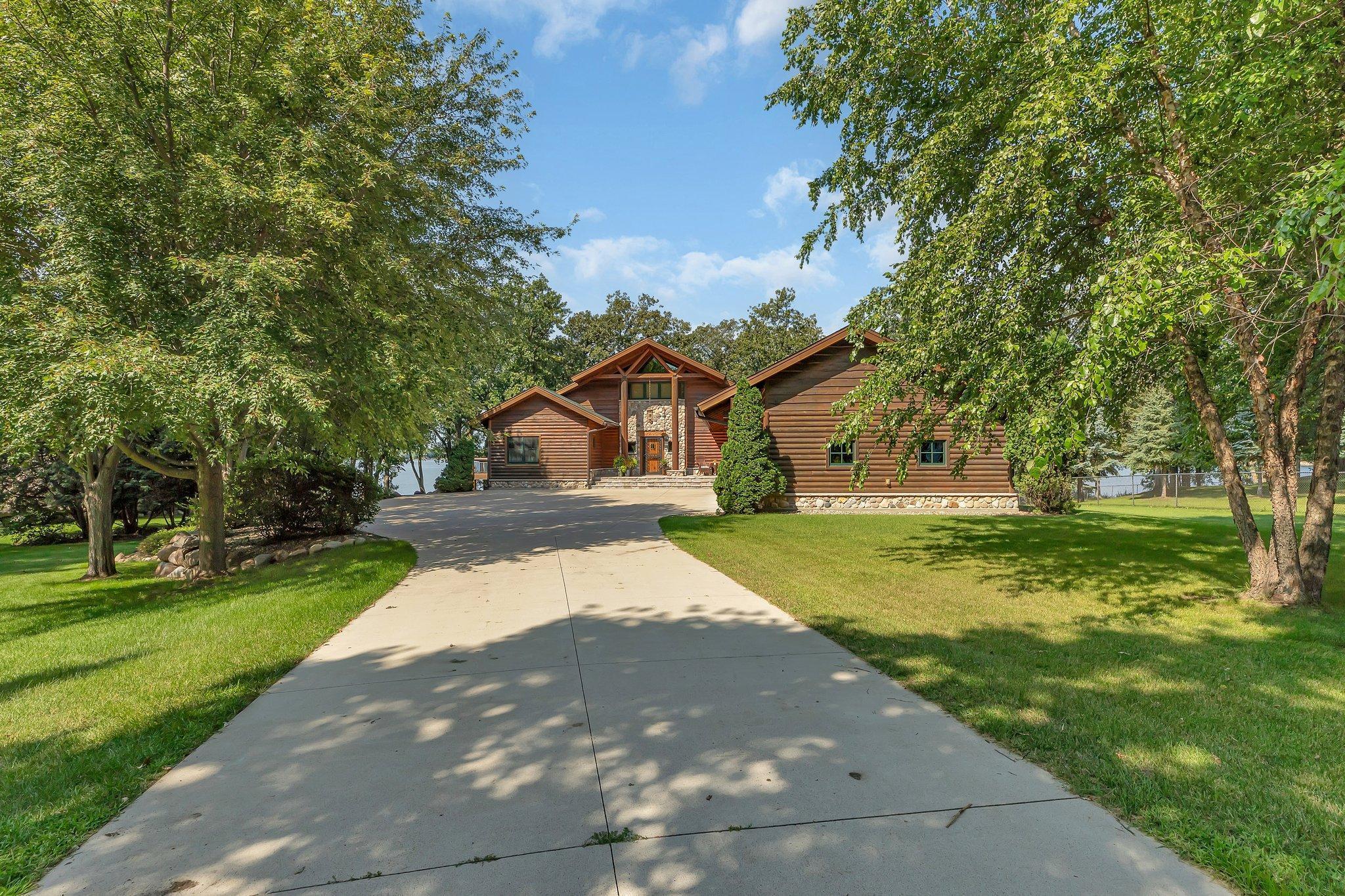 As you step onto the property, you'll be captivated by the lush and vibrant landscaping that surrounds the residence. The beautiful yard and mature trees create a harmonious blend of nature and architecture.