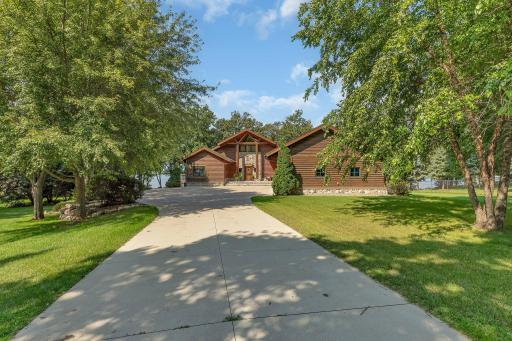 As you step onto the property, you'll be captivated by the lush and vibrant landscaping that surrounds the residence. The beautiful yard and mature trees create a harmonious blend of nature and architecture.