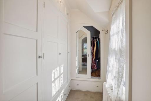 Primary suite walk-in closet with built-in cabinetry.