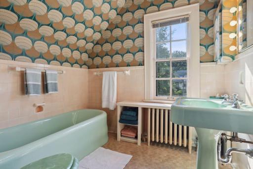 Designer wallpaper complements the original tile in the full hall bath. Service to 2nd and 3rd bedrooms.