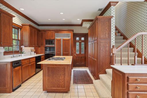 Spacious center island kitchen includes a wet bar area and breakfast nook overlooking the gardens. Side door access to sidewalk from garage. Back staircase leads to a nanny/guest bedroom suite.