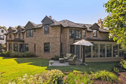 Large level backyard surrounded by garden beds and a lovely patio adjacent to the four season porch.