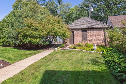 Additional yard and garden beds adjacent to the garage. The backyard is enclosed with a full perimeter wrought iron fence. The garage is off of a quiet alleyway.