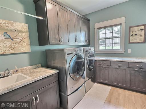 Just steps away from the primary suite is the laundry room finished with a folding counter, sink and tons of cabinet space.