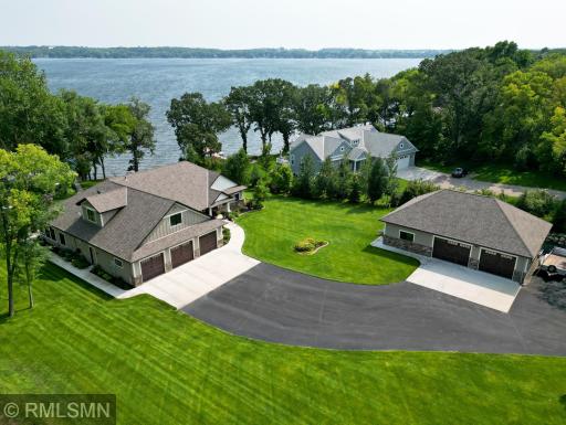 View of the home including an asphalt driveway leading to the detached garage and home.