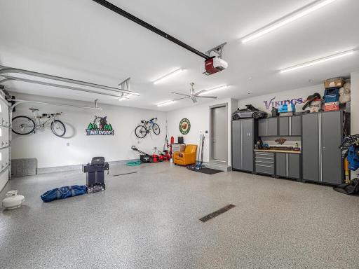 A dream oversized 3 car garage with heated floor, oversized drains for washing cars Trex no maintenance garage doors and wired for future car charging station.,