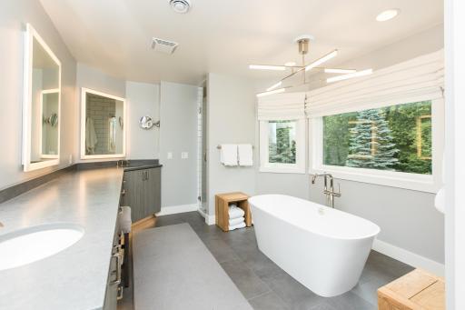 Primary spa-like bath with marble floors and walk-in shower.jpg