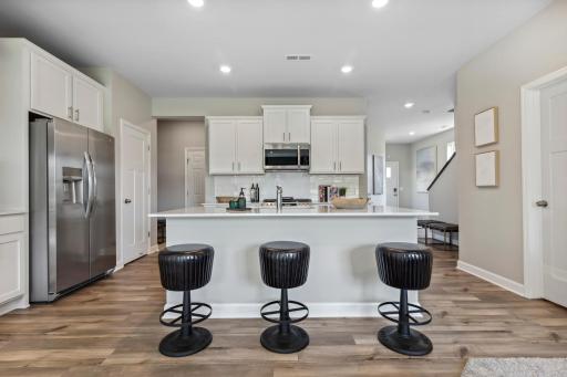 Enjoy this spacious kitchen with stylish finishes and a large kitchen island to accommodate seating. Fully equipped with stainless appliances, beautiful rich LVP flooring, quartz countertops and tile backsplash, this kitchen is sure to impress.