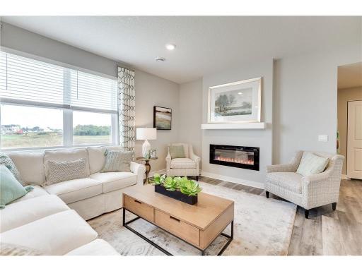 Light and bright with modern electric fireplace, this living room is a welcoming space for all. *Pictures are of a model home, actual colors and finishes may vary.