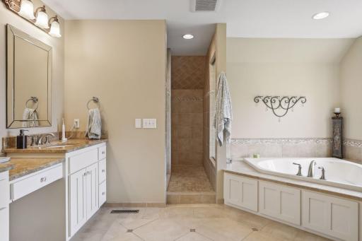 The primary bathroom is a sanctuary, with dual sinks, walk-in shower and jetted tub. The walk-in closet, professionally organized to perfection, completes this space.