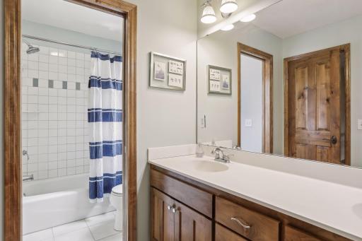There is a full bathroom, complete with dual sinks and elegant tile floors.