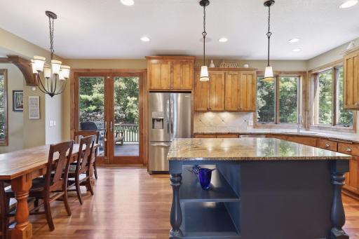 The informal dining area reveals a seamless integration of functionality and style. Cabinets and a petite drop desk offer convenience.