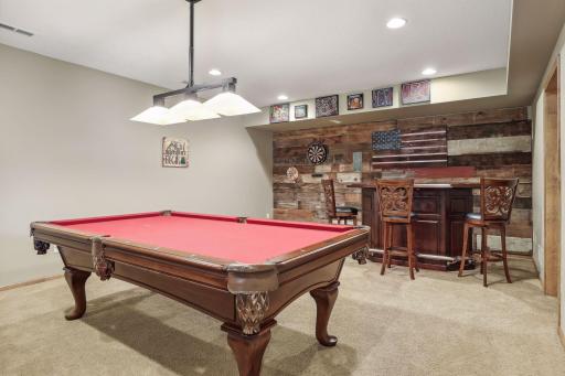 The bar area, with reclaimed wood wall, replete with rustic charm, is a space where memories are woven. The bar and chairs will stay with the home.