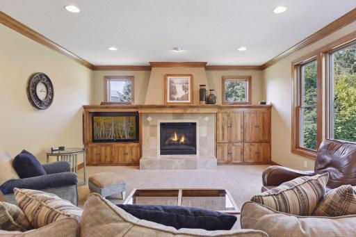 The gas fireplace becomes a central focal point and the built-in cabinets offer a combination of artistry and functionality. Large windows with panoramic views of the backyard. Crown molding throughout adds an air of sophistication.