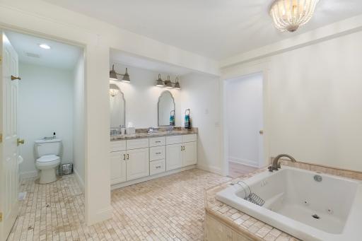 Spa like stone/soaking tub/ vanity space in primary bathroom